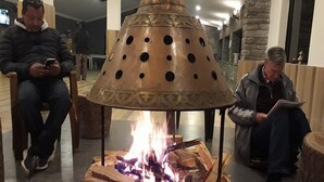 A fire pit with logs, surrounded by wooden stools and benches. - Shivapuri Village (Samundradevi)