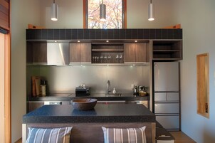 A modern kitchen with a central island, built-in appliances, and a large window.