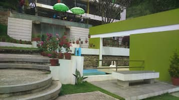 Ein Innenhof mit Pool, Stufen und Kübelpflanzen.