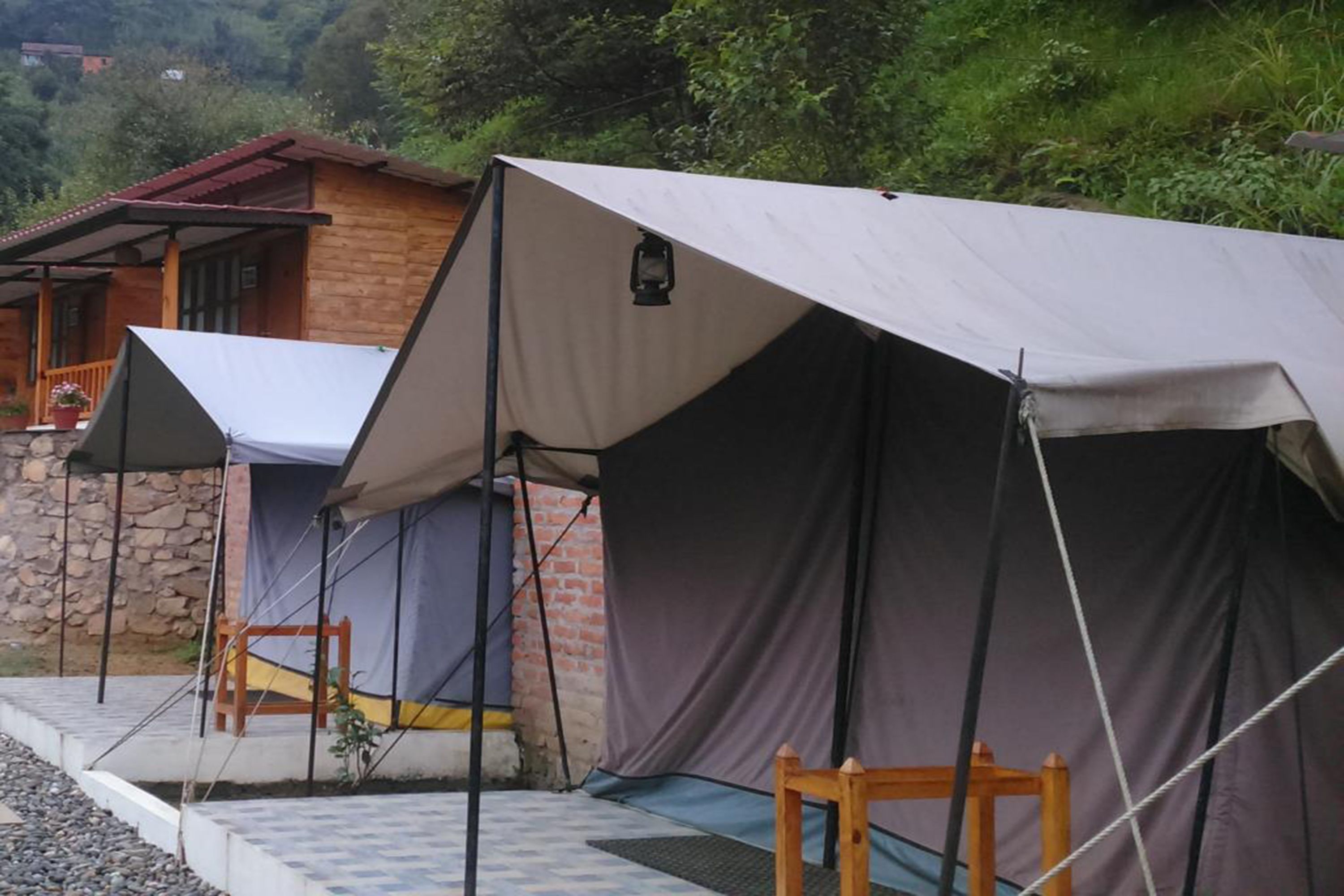 A row of tents with a stone building in the background.