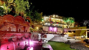 A modern building with a well-lit entrance and a fountain area. - Chhaimale Resort (Dakshinkali)