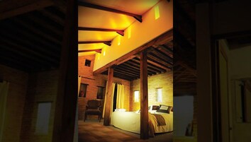 Un dormitorio con cama, una silla y una ventana.