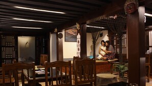 A traditional interior with wooden furniture, a decorative fan, and a painting on the wall. - Hiranya Guest House (Lalitpur)