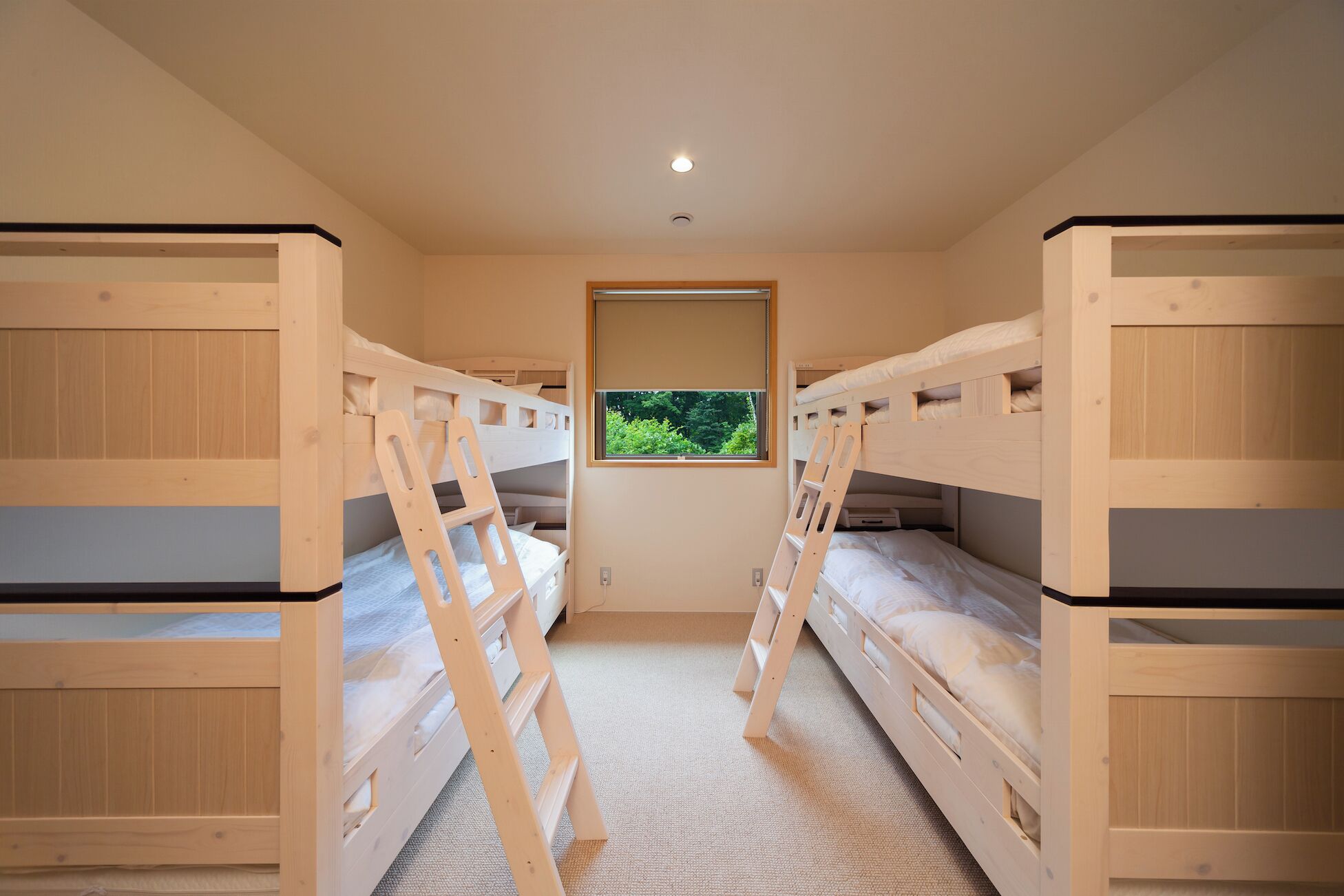 A room with bunk beds, a window, and a ladder.