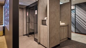 A modern elevator area with a digital display, a glass door, and a small counter. - JR WEST GROUP VIA INN SHINOSAKA (Osaka)