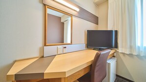 A hotel room with a wooden desk, a television, a mirror, and a window with curtains. - JR WEST GROUP VIA INN SHINOSAKA WEST (Osaka)