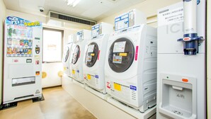 A row of white, modern laundry machines with control panels and a water dispenser. - JR WEST GROUP VIA INN SHINOSAKA WEST (Osaka)