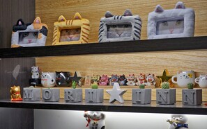 A shelf with various cat-themed items, including figurines and mugs, and a 'MORINN' sign.