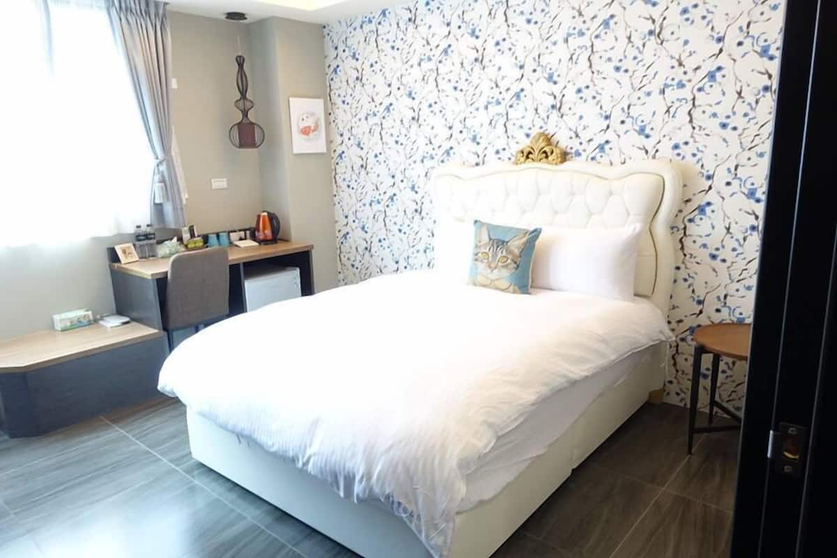 Un dormitorio con una cama grande, un escritorio y una silla.