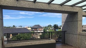 Un balcón con vista a edificios y árboles.