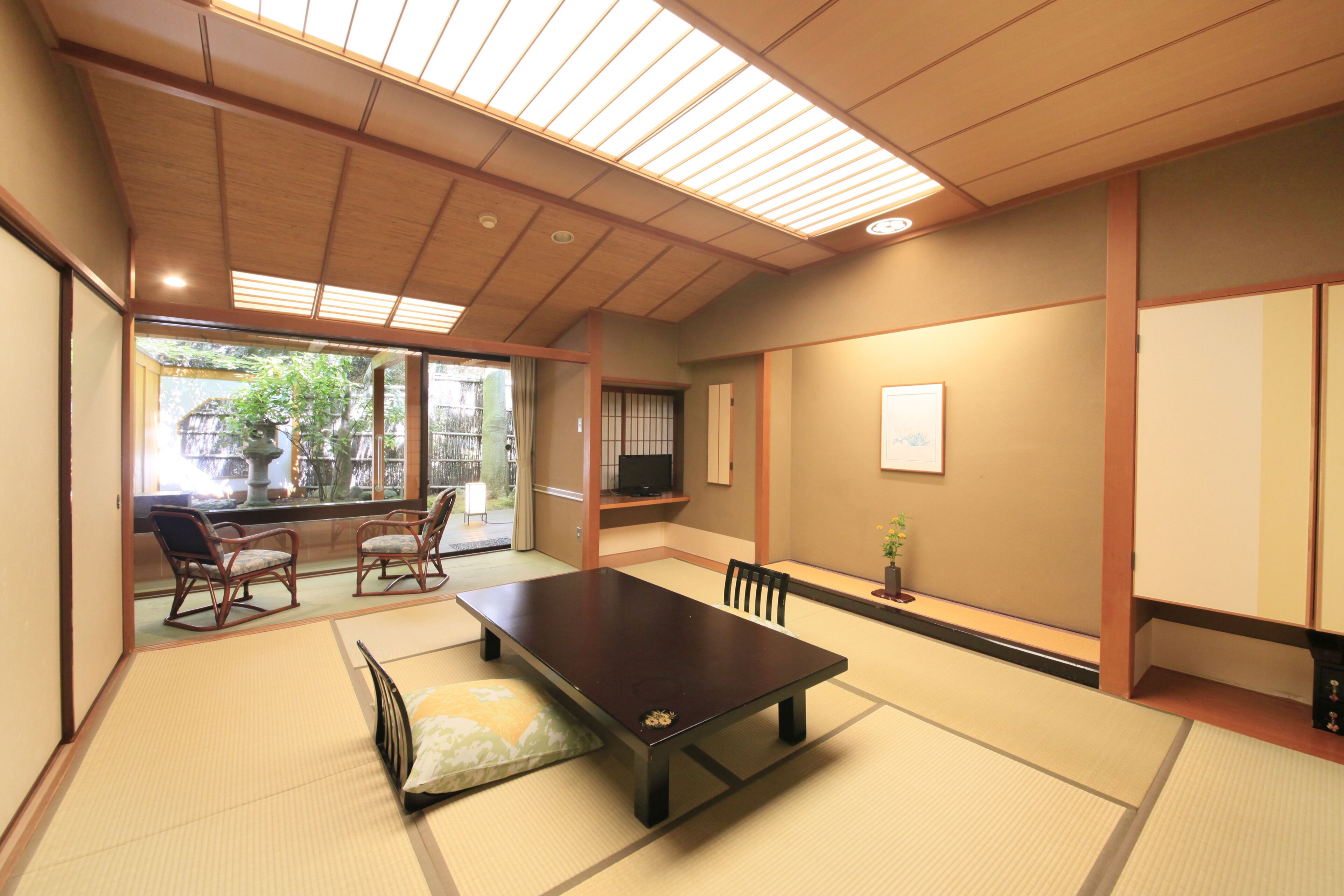 A traditional Japanese room with tatami flooring, a low table, and sliding doors.