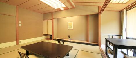 Um quarto japonês tradicional com tatames, uma mesa baixa e uma porta deslizante.