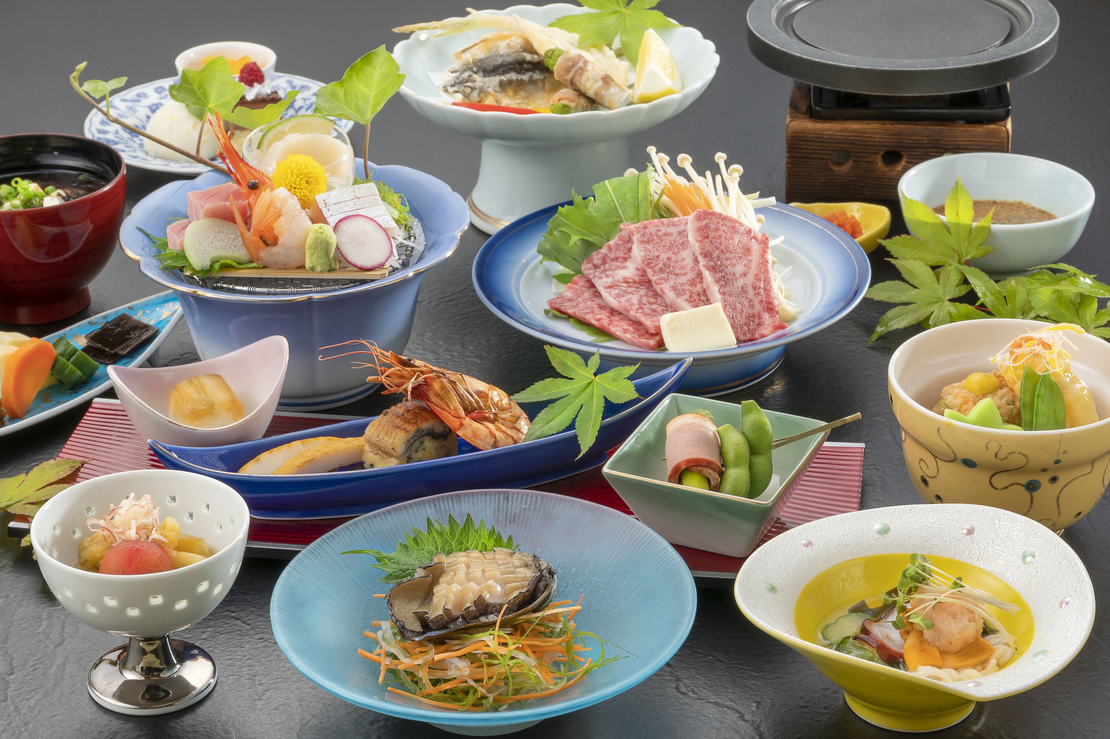 A variety of dishes arranged on a table, including seafood, vegetables, and other food items.