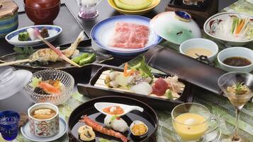 Variedade de pratos e bebidas japoneses sobre uma mesa, incluindo sushi, sashimi e um pote quente.