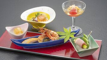 A variety of Japanese dishes on a table with a red placemat.
