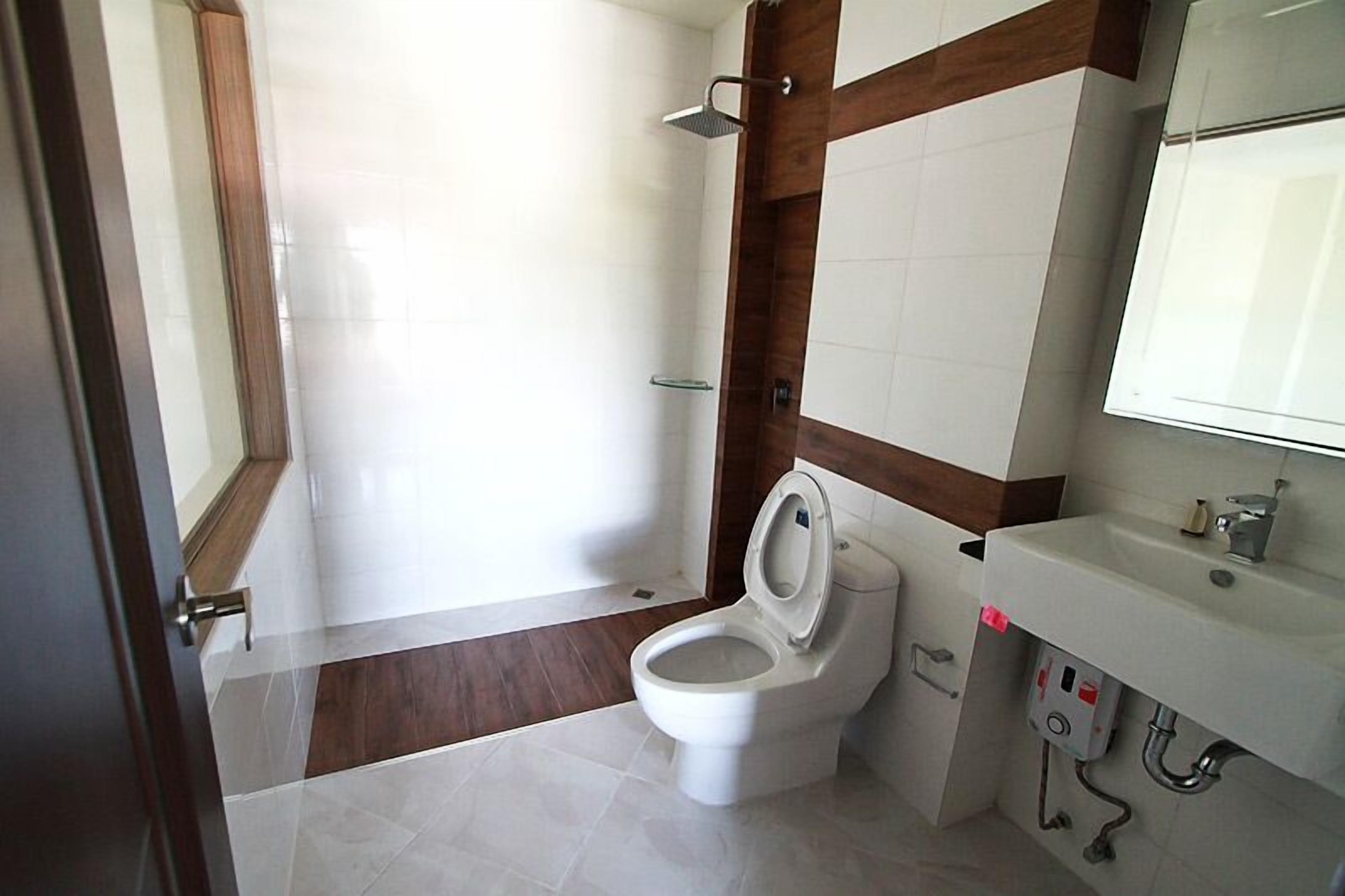 Een badkamer met toilet, wastafel en douche.