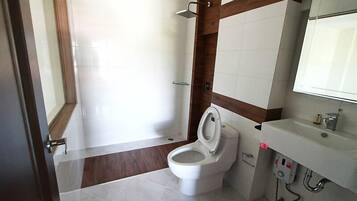 Een badkamer met toilet, wastafel en douche.