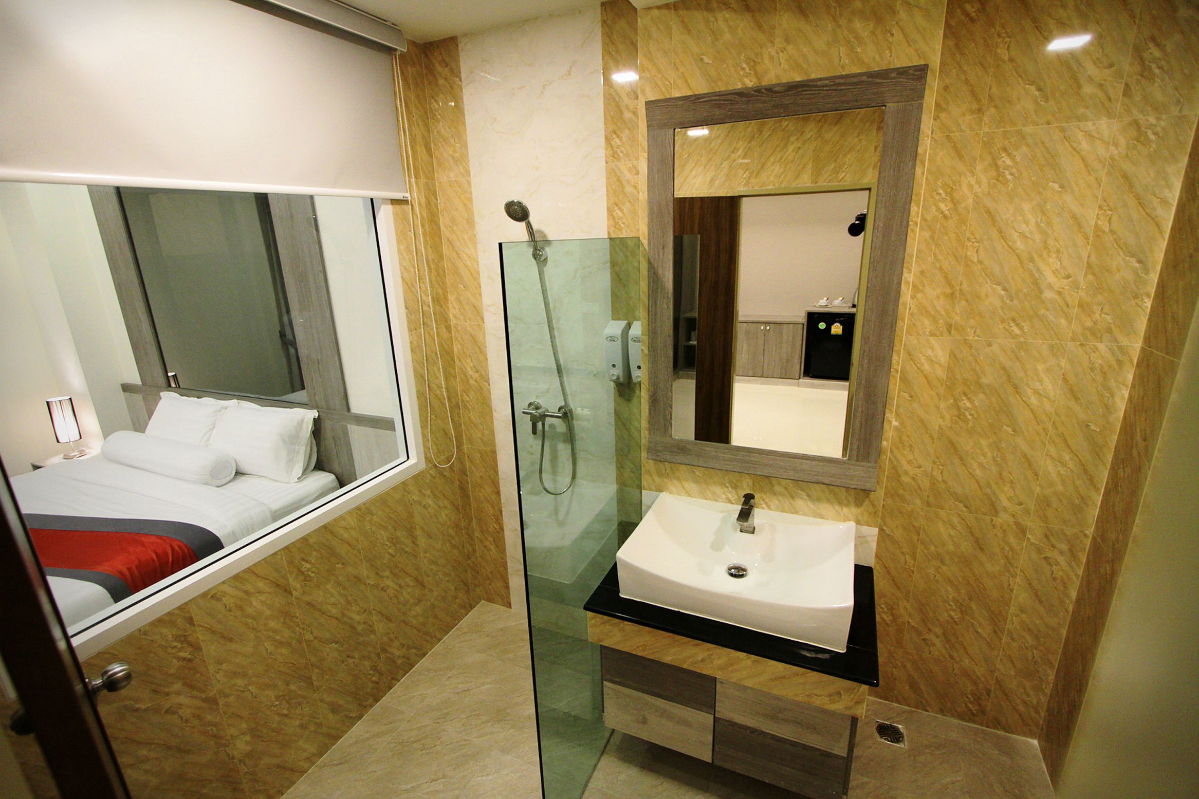 Un baño moderno con cabina de ducha de vidrio, un lavabo blanco y un espejo grande encima.