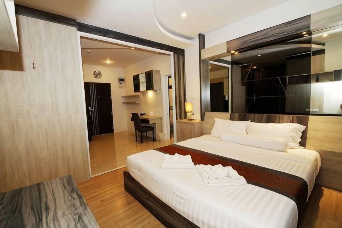 Une chambre d’hôtel moderne dotée d’un grand lit, d’un bureau et d’un coin salon séparé.
