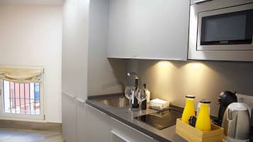 A modern kitchen with a built-in microwave, a sink, and a wooden wine cooler containing bottles.