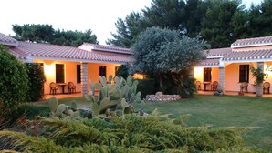 Un patio con dos edificios, cada uno con techo de tejas y mobiliario exterior.