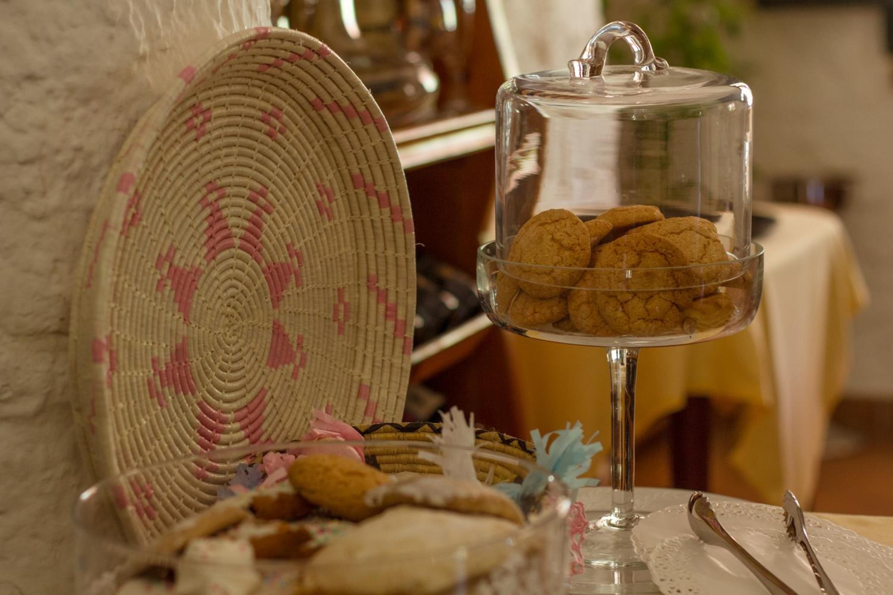 A glass display case with cookies and a woven plate beside it.