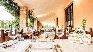 Un restaurante con mesas dispuestas para comer, un letrero que indica 'sapequera' como el nombre del local, y vista al área exterior.