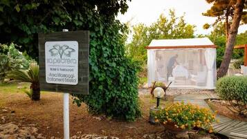 Segnale per 'sapedra Hotel & Restaurant' con area giardino, una struttura a forma di tenda e un vialetto.