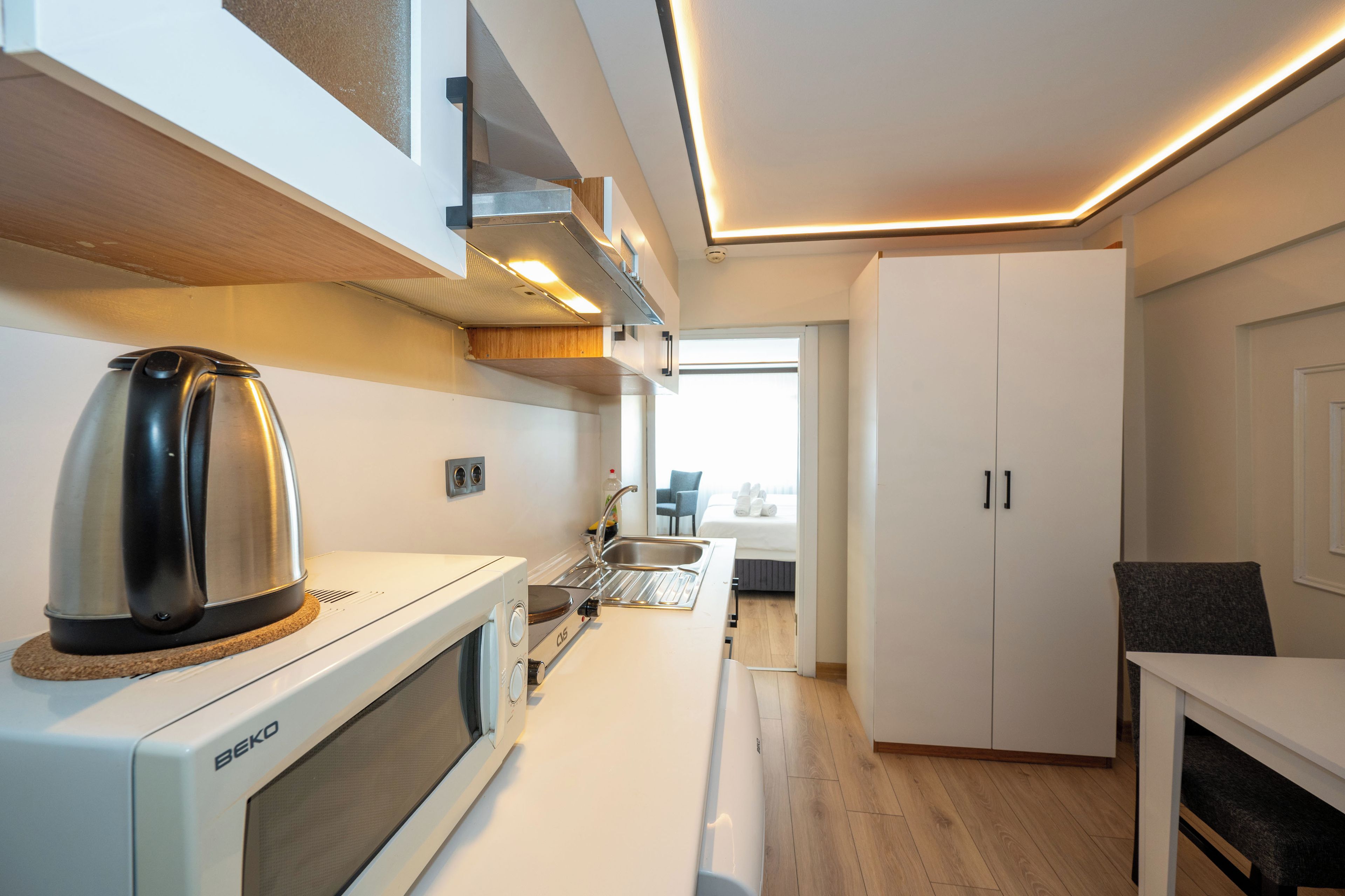 A modern kitchen with a kettle, microwave, and sink.