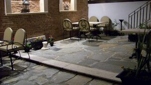 An outdoor patio with stone flooring, a brick wall, and a staircase. - Hotel Edirne Osmanli Evleri (Edirne)