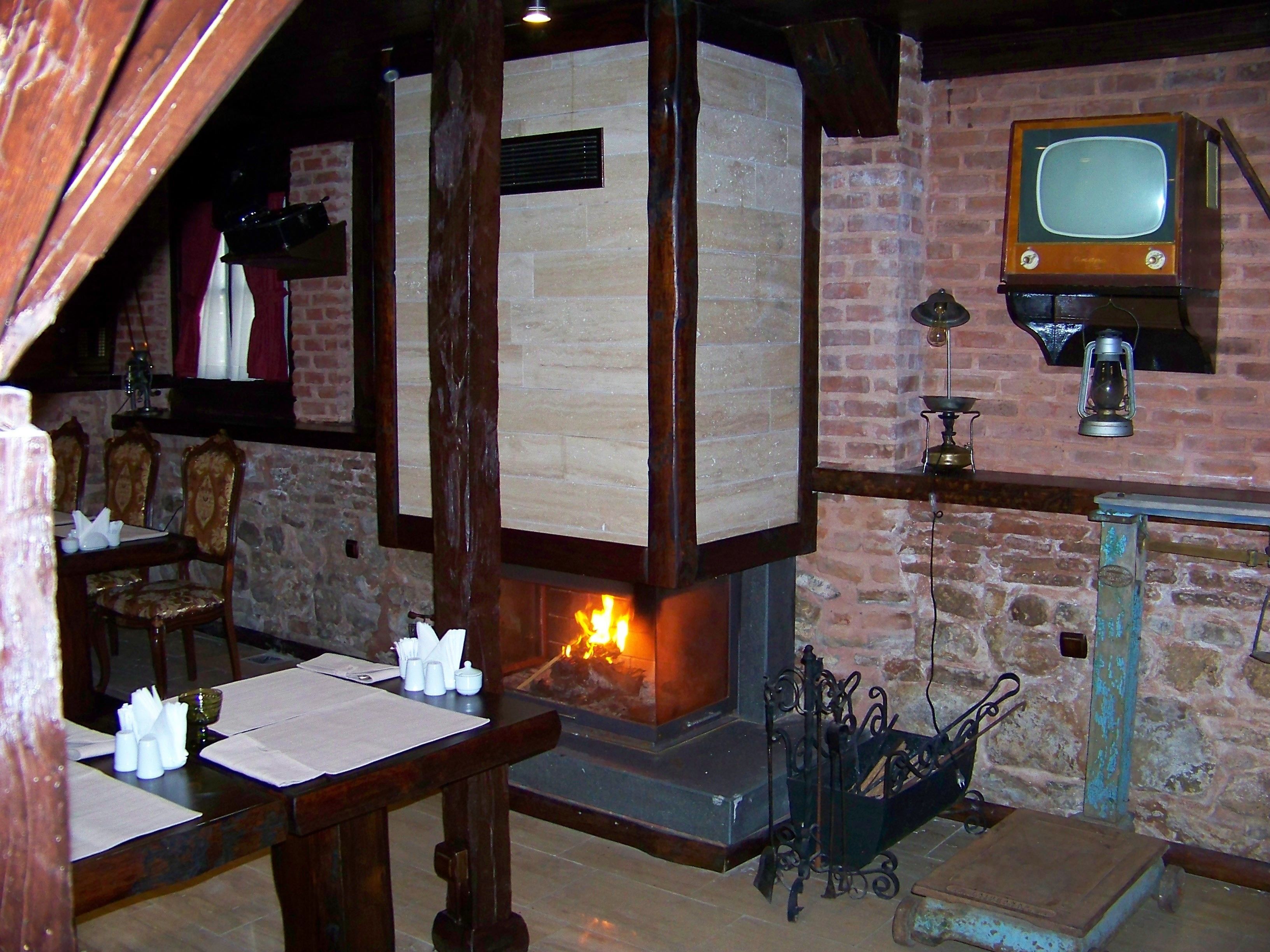 A rustic room with a fireplace, wooden furniture, and a vintage television.