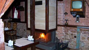 A rustic room with a fireplace, wooden furniture, and a vintage television.
