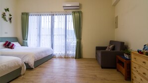 Un dormitorio con dos camas, un sofá, un aparador y una ventana con cortinas.