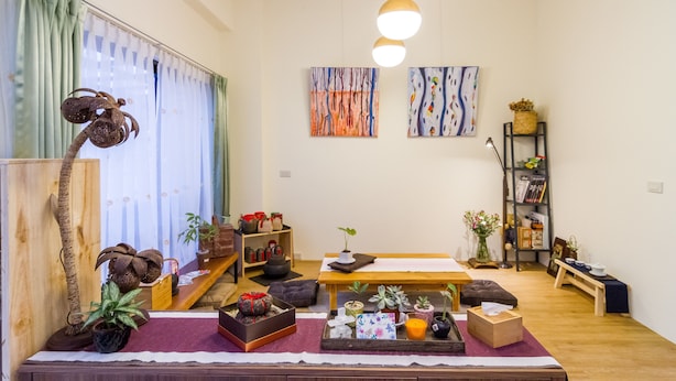 Un salón acogedor con una mesa de madera, un sofá y una estantería.