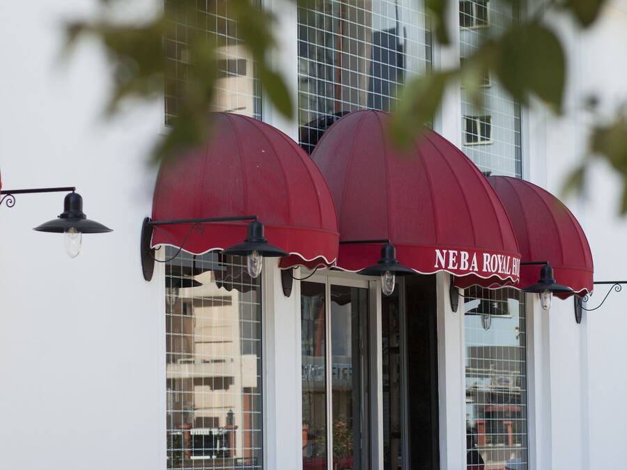 A building with a red awning and the name "NEBA ROYAL HOTEL" visible.