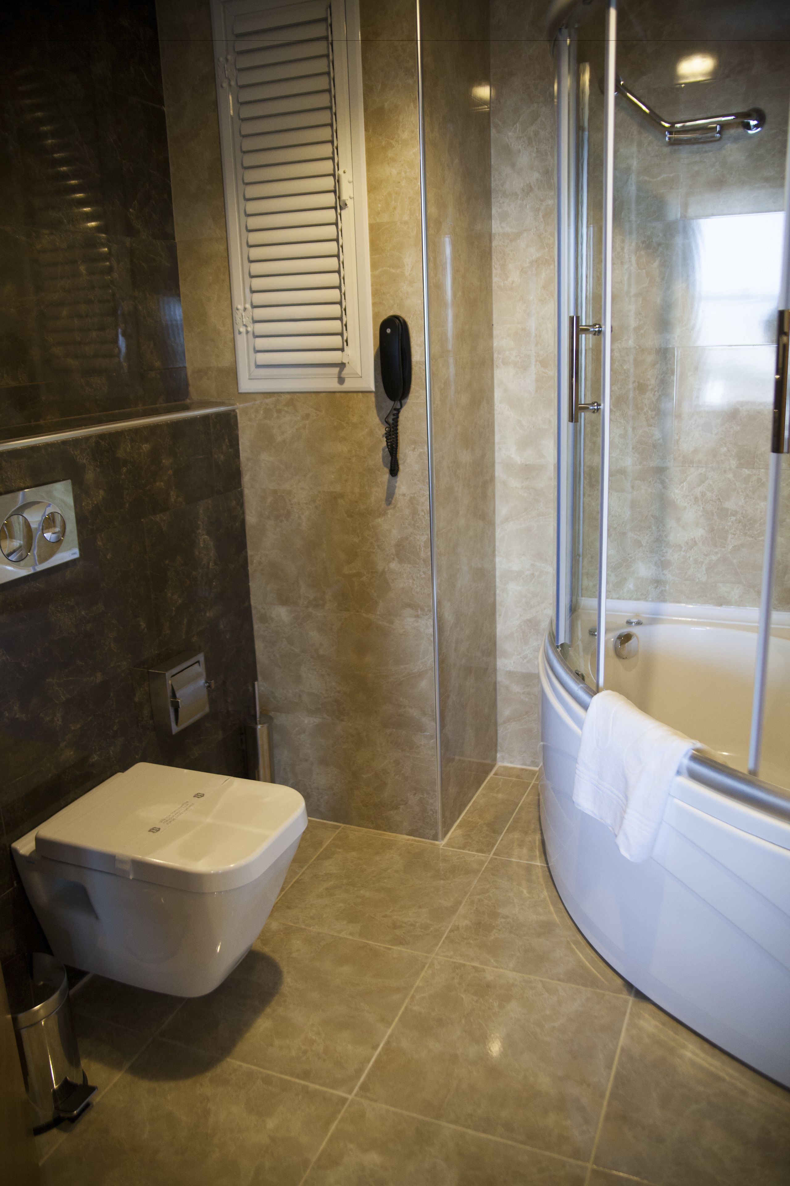 Une salle de bain comprenant des toilettes, un espace douche et une baignoire.