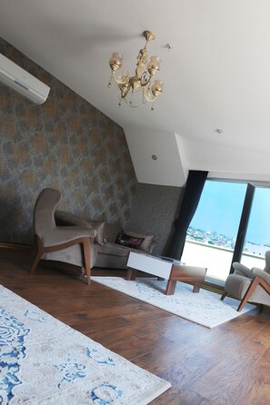 Suite de lujo, 1 cama de matrimonio grande | Zona de estar | Una televisión LCD