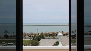 Vista da área costeira com uma ponte, edifícios e um farol.