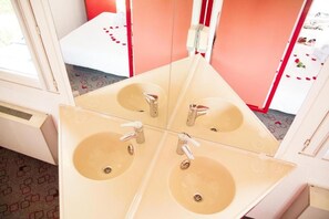 A bathroom with four sinks and mirrors.