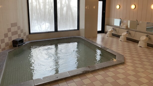 Ein Spa-Bereich mit großem Fenster, einer Whirlwanne und einer Dusche.