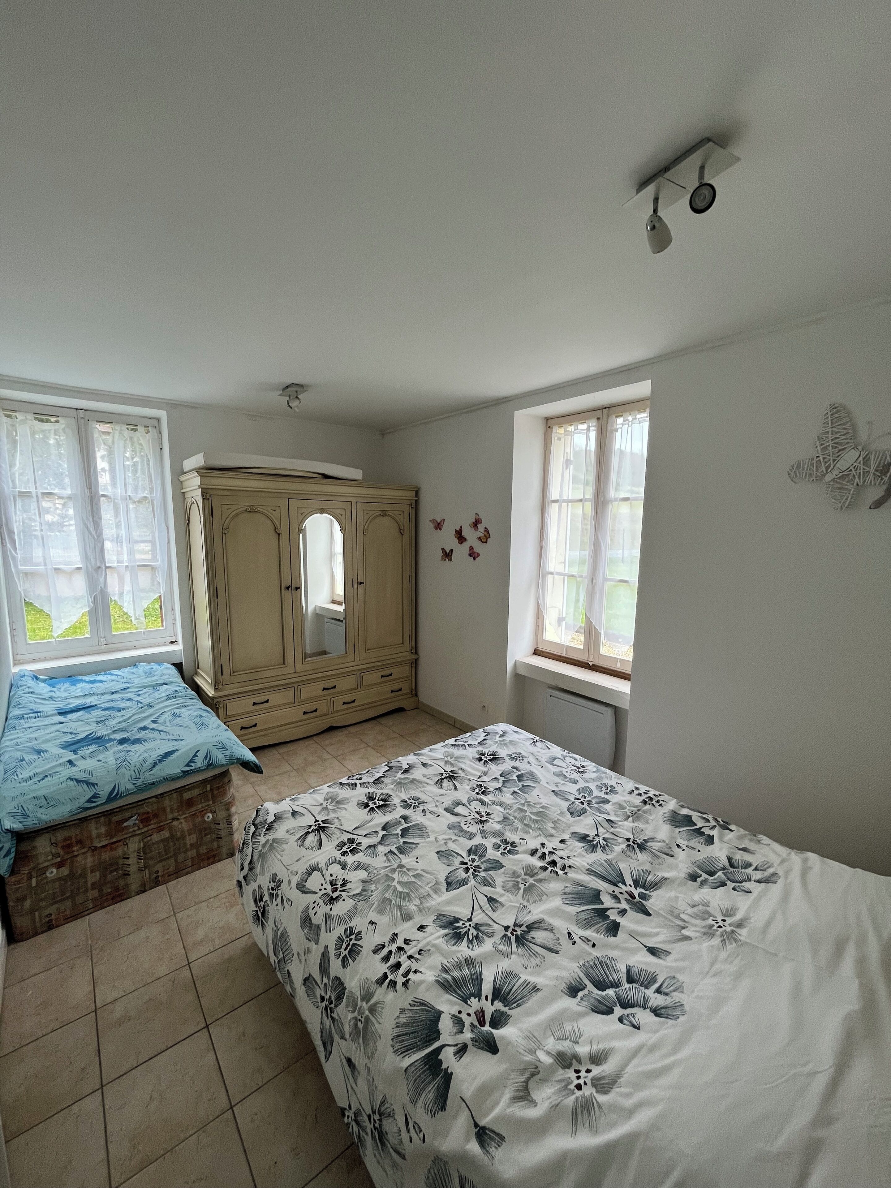 Un dormitorio con cama, cómoda y ventana.
