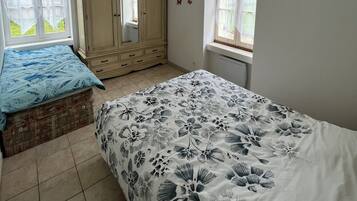 Un dormitorio con cama, cómoda y ventana.