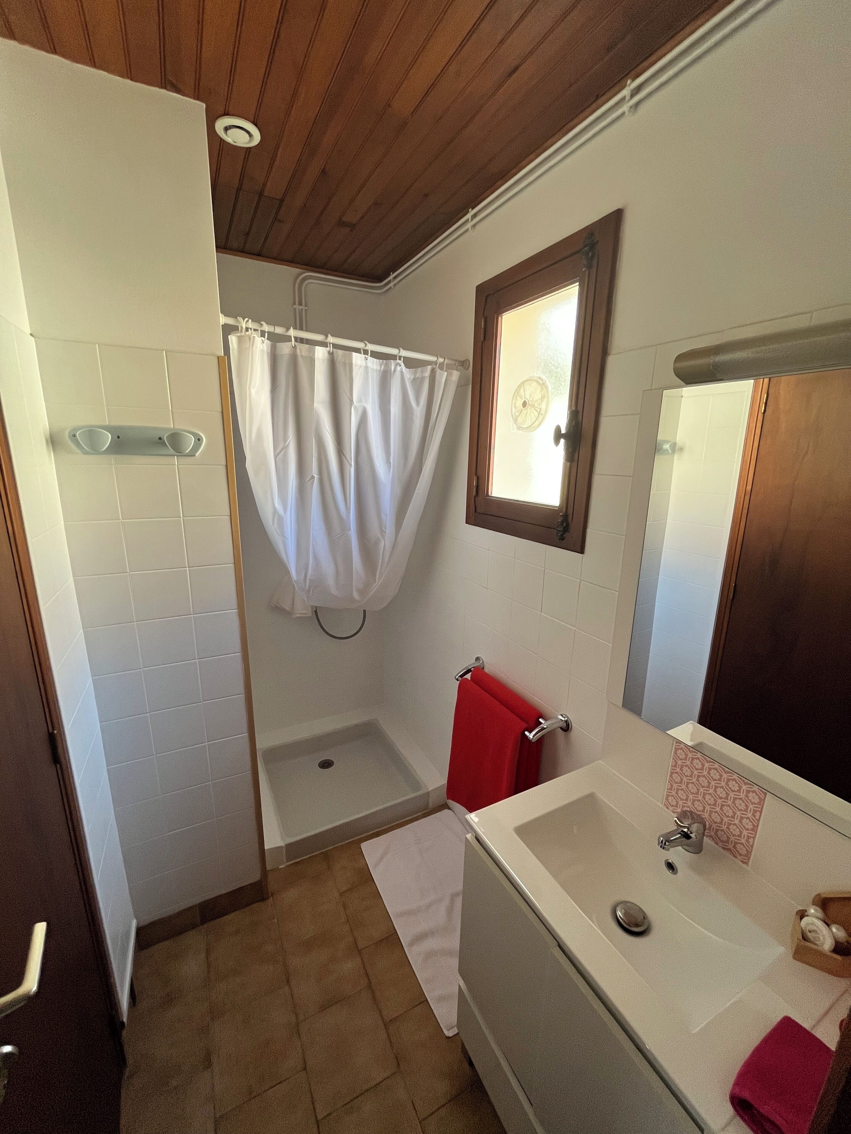 Une salle de bain équipée d’une douche, d’une baignoire, d’un lavabo et d’un miroir.