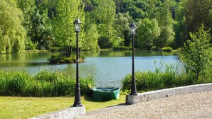 Une vue paisible sur un lac, avec un bateau amarré près de deux lampadaires.