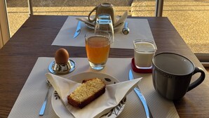 Une table avec une part de gâteau, un verre de thé, une tasse à café et une théière.