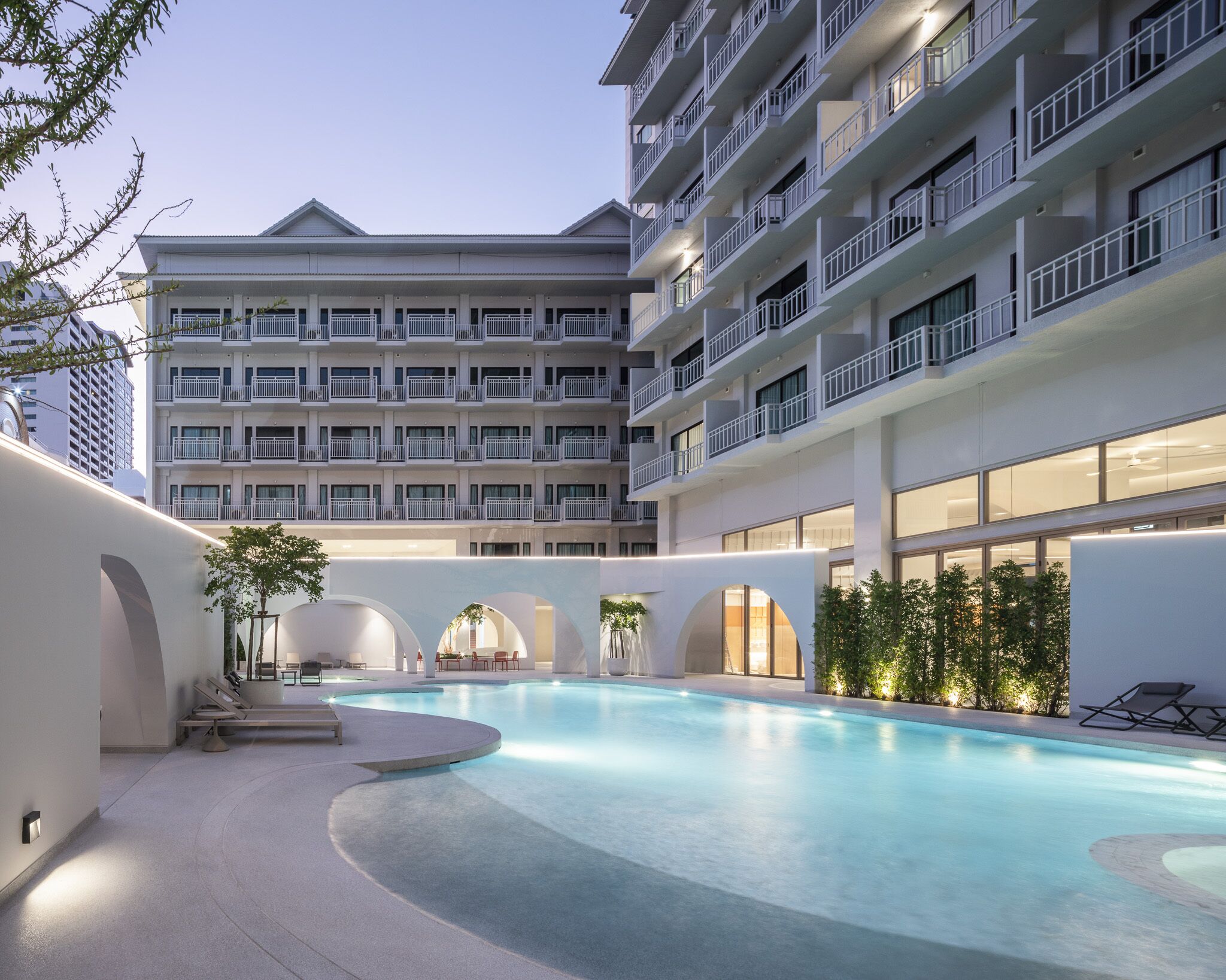 Una piscina al aire libre, sombrillas, sillones reclinables de piscina