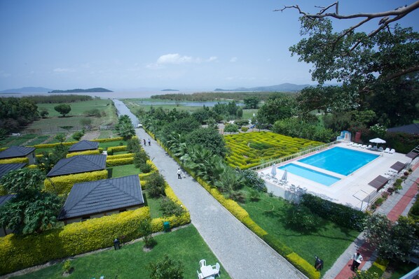 A resort with a swimming pool, neatly trimmed gardens, and a view of the sea. - Haile Resort Ziway (Ziway)