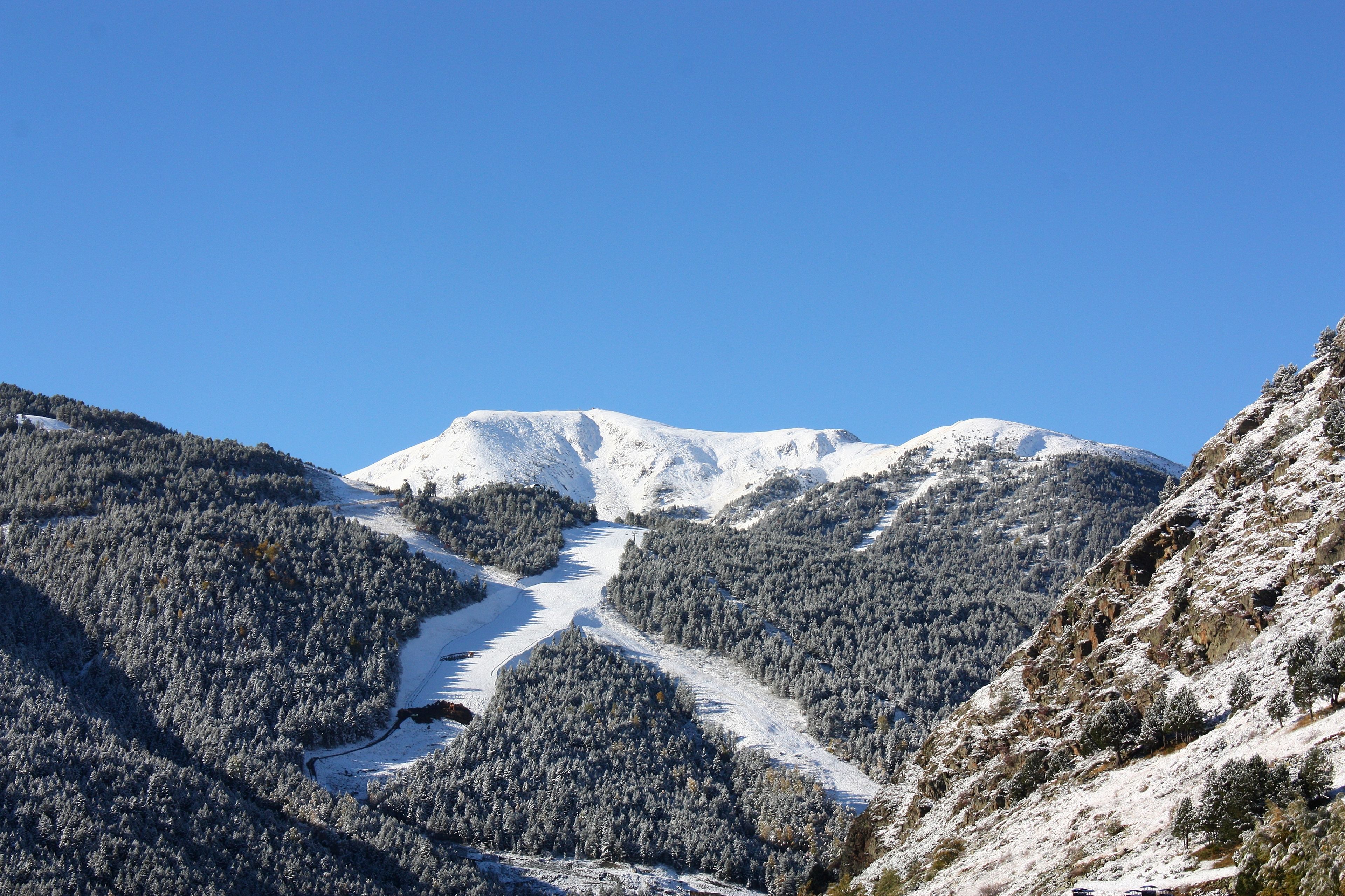 Paisatge de muntanya coberta de neu amb un cel serè.