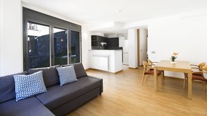 A modern apartment with a living area, kitchen, and dining space. - Font del Ferro Apartaments (Ransol)