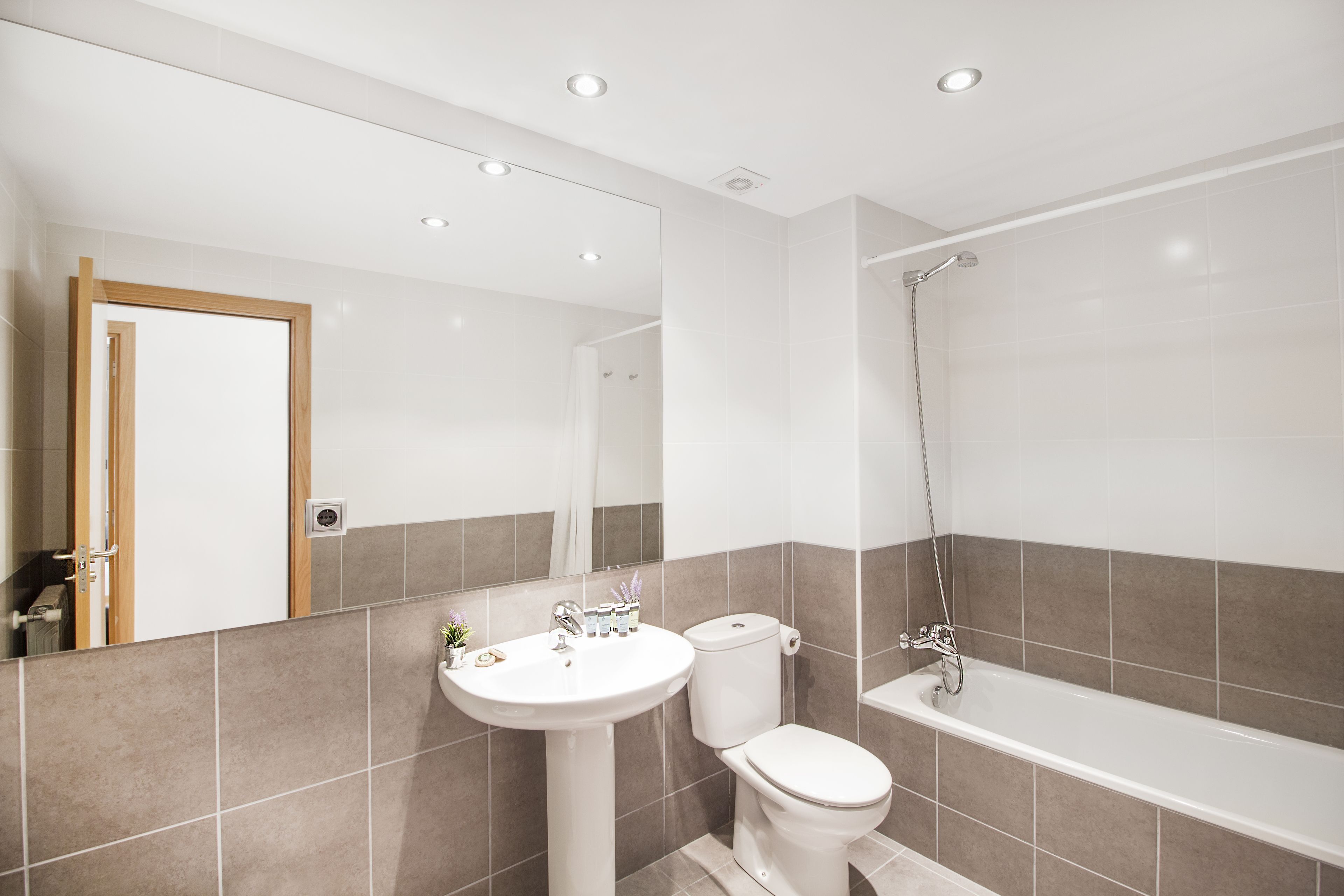 A modern bathroom with a sink, toilet, and bathtub.